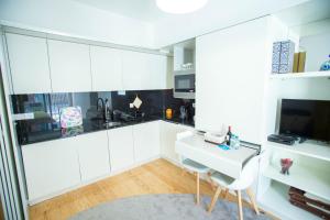 a kitchen with white cabinets and a white table and chairs at Almada Story Apartments by Porto City Hosts in Porto