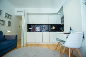 a kitchen with white cabinets and a blue couch at Almada Story Apartments by Porto City Hosts in Porto