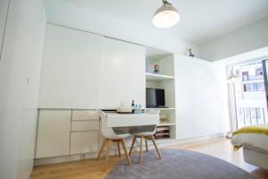 a white kitchen with a table and chairs in a room at Almada Story Apartments by Porto City Hosts in Porto