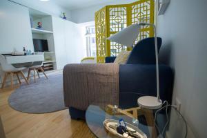 a living room with a blue couch and a table at Almada Story Apartments by Porto City Hosts in Porto