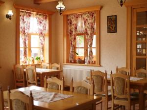 a dining room with tables and chairs and windows at Hostinec Babia hora in Oravská Polhora