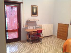 a room with a table and chairs on a carpet at Bed & Breakfast da Charlie in LʼAquila