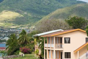 a house with a mountain in the background at Bird Rock Beach Hotel in Basseterre