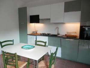 a kitchen with a table and a white table and chairs at Dèpendance Argentario in Porto Santo Stefano