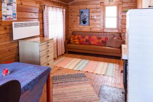 une chambre avec un canapé dans une cabane en bois dans l'établissement Villa North Karelia by offerhut 25, à Onkamon Kannas