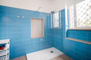 a blue tiled bathroom with a tub and a window at B&B Casina de Goyzueta in Torre del Greco +60 photos