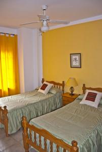 ルイデラにあるCasa Ruyderaの黄色い壁の客室内のベッド2台