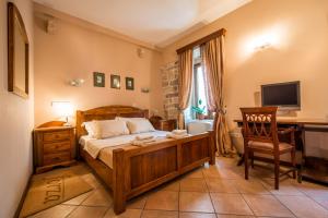 a bedroom with a bed and a desk with a computer at Guest House Forza Lux in Kotor