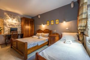 a bedroom with two twin beds and a desk at Guest House Forza Lux in Kotor