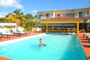 巴斯特尔Bird Rock Beach Hotel的一名男子在酒店游泳池里