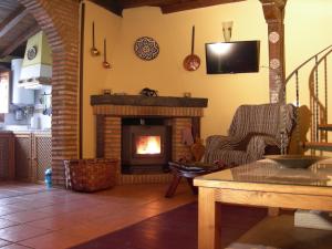 a living room with a fireplace and a tv at La casa del Vado in Hervás