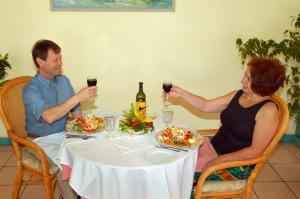 a man and woman sitting at a table drinking wine at Bird Rock Beach Hotel in Basseterre