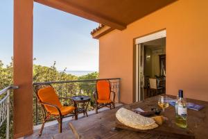 balcón con mesa, sillas y vistas al océano en Casa Giovanni, en Cala Gonone