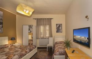ピサにあるHotel Il Giardinoのベッド2台、薄型テレビが備わるホテルルームです。