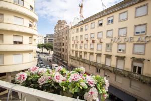 a balcony with pink flowers in front of a building at Almada Story Apartments by Porto City Hosts in Porto
