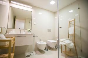 a bathroom with a sink and a toilet and a mirror at Almada Story Apartments by Porto City Hosts in Porto +37 photos