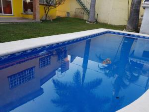 een blauw zwembad met reflectie in het water bij Casa los Peregrina in Cuernavaca