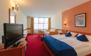 um quarto de hotel com uma cama e uma televisão de ecrã plano em Hotel Mediterran em Budapeste