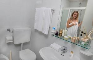 a woman taking a picture of herself in a bathroom mirror at Hotel Piccadilly in Bellaria-Igea Marina +57 photos