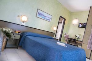 a bedroom with a blue bed and a desk at Hotel Piccadilly in Bellaria-Igea Marina