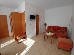 sala de estar con sofá rojo y mesa en Lei's WOK, en Neusiedl am See