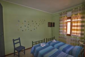 ティヴォリ・テルメにあるL'Orchidea di Aleのベッドルーム1室(ベッド2台、椅子、窓付)