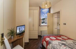 a bedroom with a bed and a desk with a television at Hotel Il Giardino in Pisa