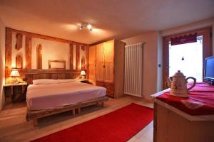 a bedroom with a bed and a television in it at Maso Toneto in Castello di Fiemme