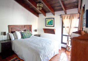 - une chambre avec un lit blanc et une fenêtre dans l'établissement Villas Santa Ana, à Antigua Guatemala
