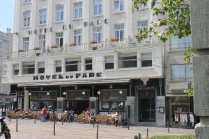 a hotel on the street with people sitting outside of it at Hotel Du Parc in Ostend
