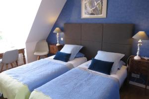um quarto de hotel com duas camas com paredes azuis em A la Maison du Héron em Villeneuve d'Ascq
