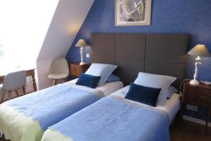 una camera d'albergo con due letti e pareti blu di A la Maison du Héron a Villeneuve d'Ascq Altre 26 foto