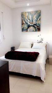 a bedroom with a bed with a painting on the wall at Studio Centre Agdal Rabat in Rabat