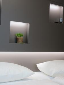 ein Spiegel über einem Bett mit Topfpflanze drauf in der Unterkunft Hotel Neuthor in Ulm