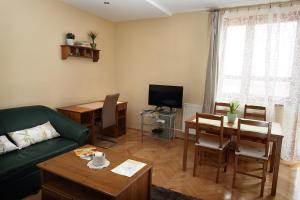 uma sala de estar com um sofá, uma mesa e uma televisão em ECOmfort Apartment em Kecskemét