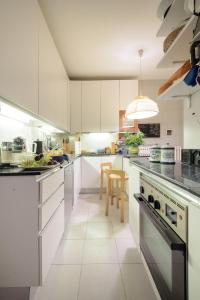 una cucina con mobili bianchi e ripiani neri di Punta Ala Luxury Villa a Punta Ala Altre 27 foto