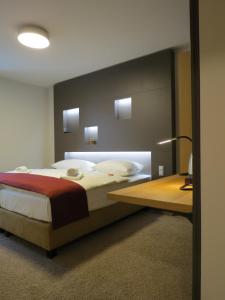 a bedroom with a large bed and a desk at Hotel Neuthor in Ulm