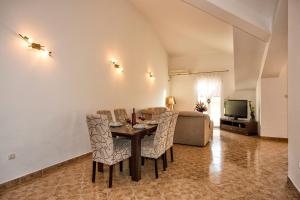 een woonkamer met een tafel, stoelen en een bank bij Apartment Sun Village Goran in Herceg-Novi