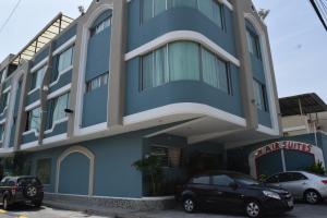 un edificio azul con coches estacionados frente a él en Hotel Air Suites, en Guayaquil