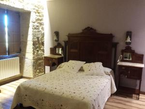 um quarto com uma cama com um edredão branco em Casa da Torre em Valga