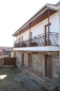 un edificio con un balcón en el lateral. en Casa do Ti Latoeiro en Torre de Moncorvo