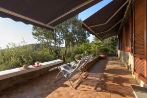 un patio con una sedia e un ombrellone di Punta Ala Luxury Villa a Punta Ala