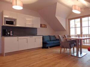 a kitchen and living room with a table and a couch at Sportlerhof - Alimann UaB in Grünau im Almtal