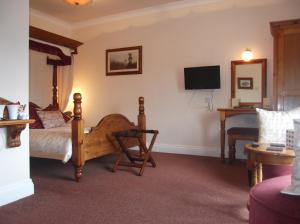 a hotel room with a bed and a television at Brandon Lodge in Hereford