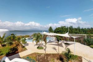 Maya Beach的住宿－Swan Villas，一个带游泳池和白色天篷的度假胜地