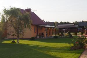 una casa con un patio con césped verde en Namelis Rugilė, en Druskininkai