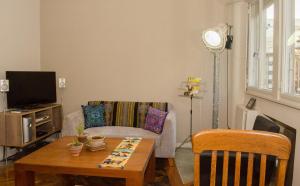 Una sala de estar con una mesa y un televisor. en Apartamento La Diagonal, en Buenos Aires