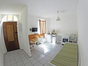 a room with a kitchen with a table and a door at Apartment La Bigatera in Castelveccana