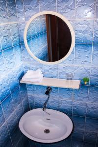a blue tiled bathroom with a sink and a mirror at Dalia in Omiš