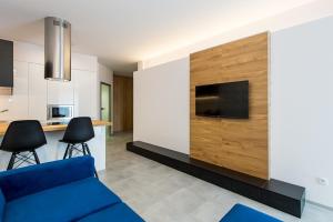 Una sala de estar con un sofá azul y una cocina. en Super-Apartamenty Luxury, en Poznan